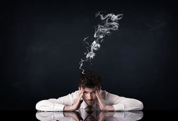 Young depressed businessman sitting with smoking head